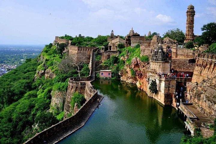 Üppige grüne Landschaft rund um die Mauern, Gebäude und das Reservoir des Chittorgarh Forts