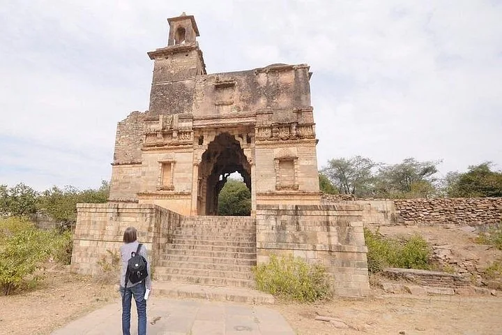 Tourist betrachtet eine alte steinerne Torruine mit Treppen im Chittorgarh Fort